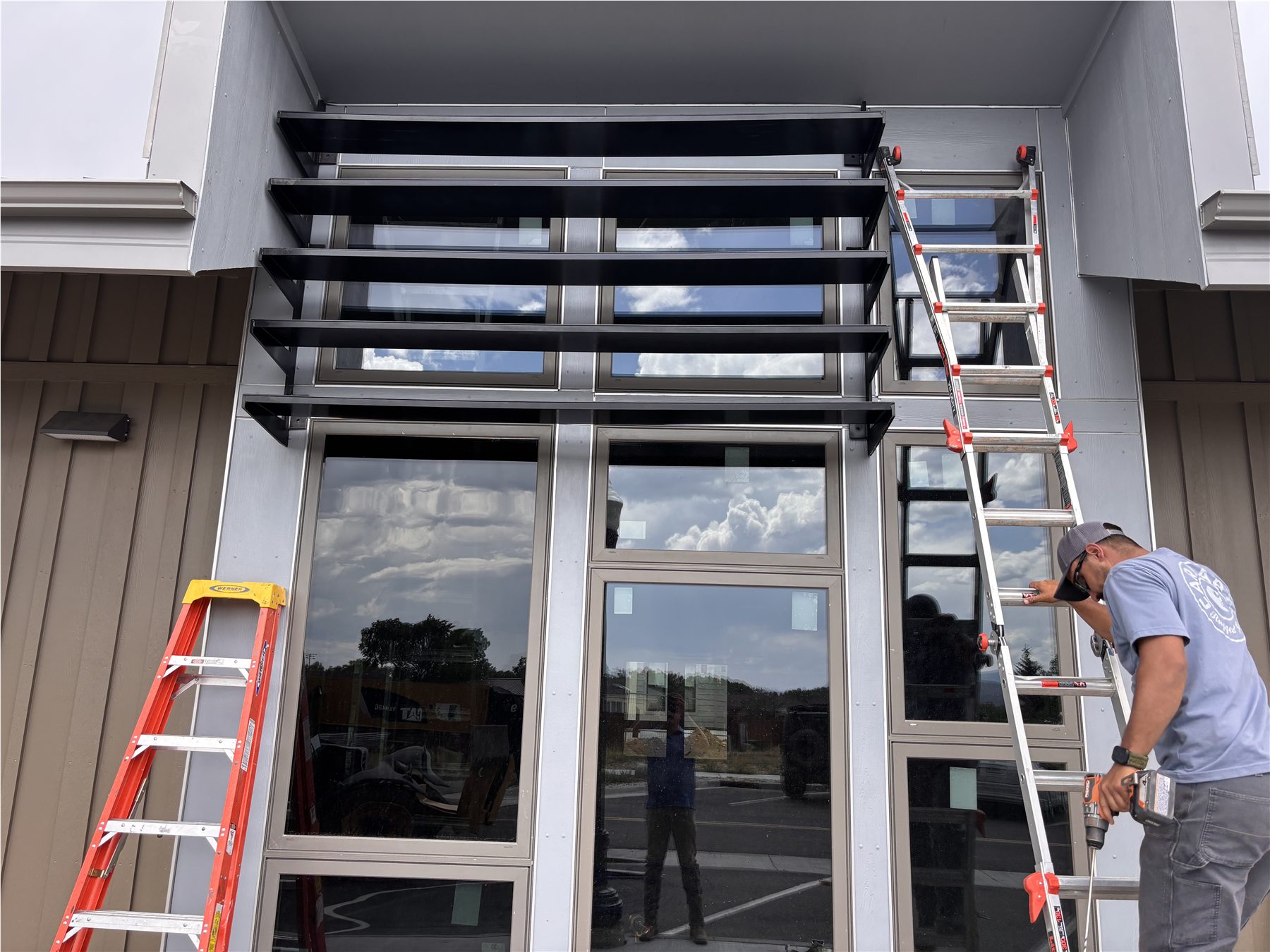 Custom black metal window louvers installed on a modern building